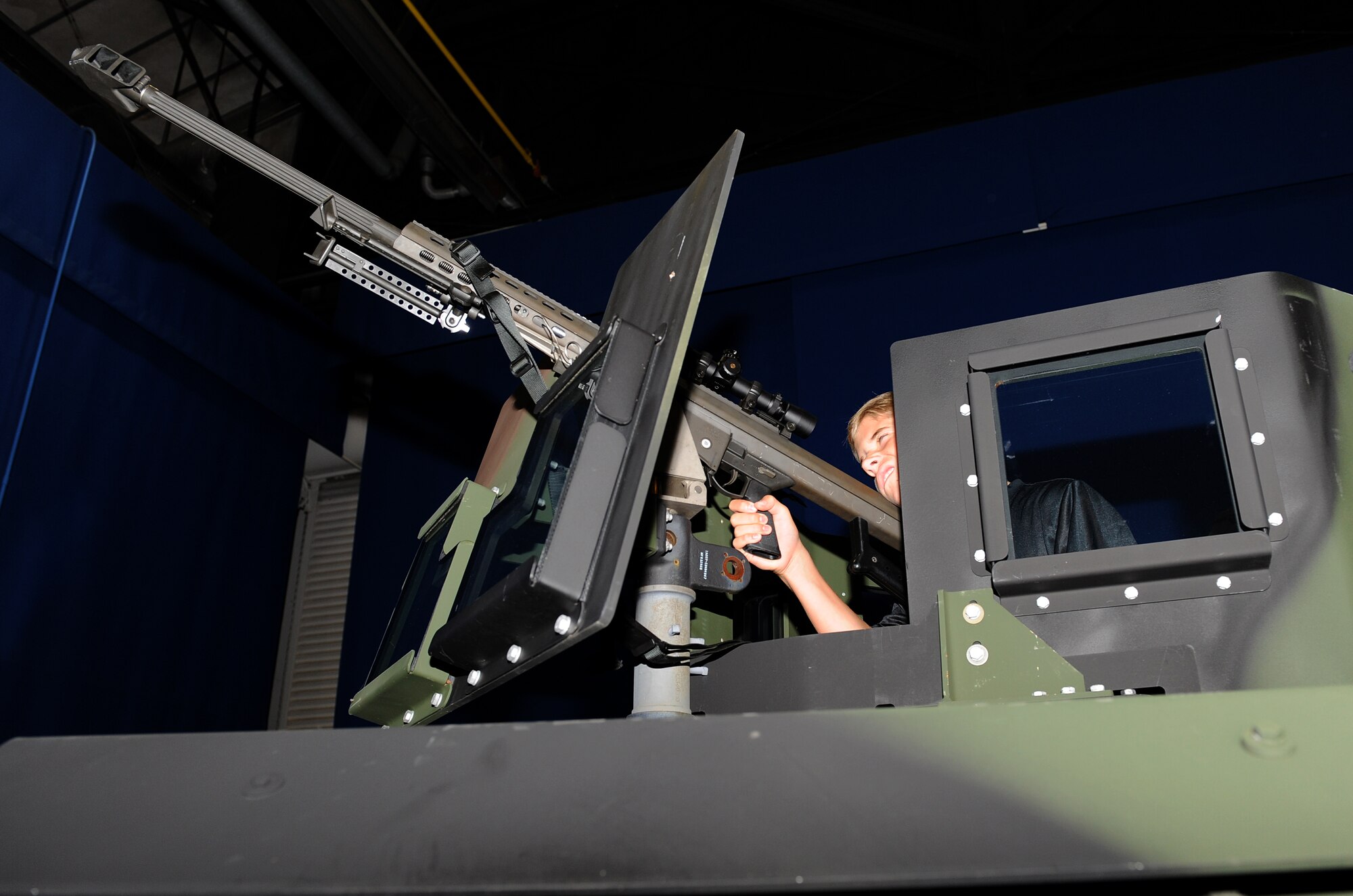 Tyler Percivalle simulates firing a .50-caliber M-107 sniper rifle out of a Humvee at the annual Operation Hero event at Langley Air Force Base, Va., Aug. 7, 2013. More than 280 children, families and volunteers participated in the day’s activities. (U.S. Air Force photo by Senior Airman Brittany Paerschke-O’Brien/Released) 