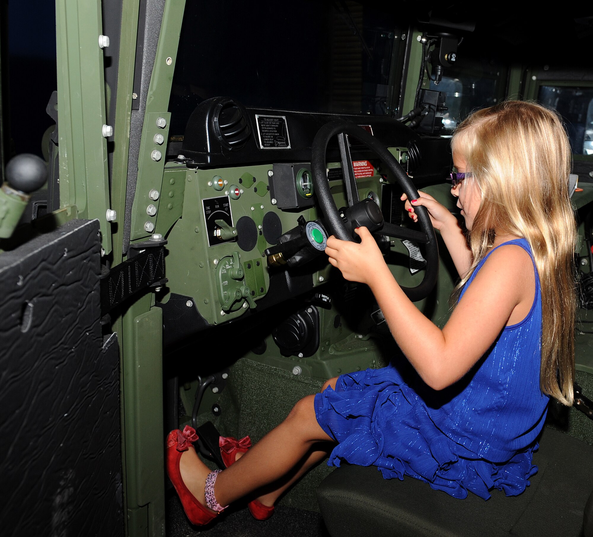 Anne Percivalle simulates driving a Humvee while participating in the annual Operation Hero event at Langley Air Force Base, Va., Aug. 7, 2013. Operation Hero helps Service members’ children understand the pre-deployment requirement process. (U.S. Air Force photo by Senior Airman Brittany Paerschke-O’Brien/Released)