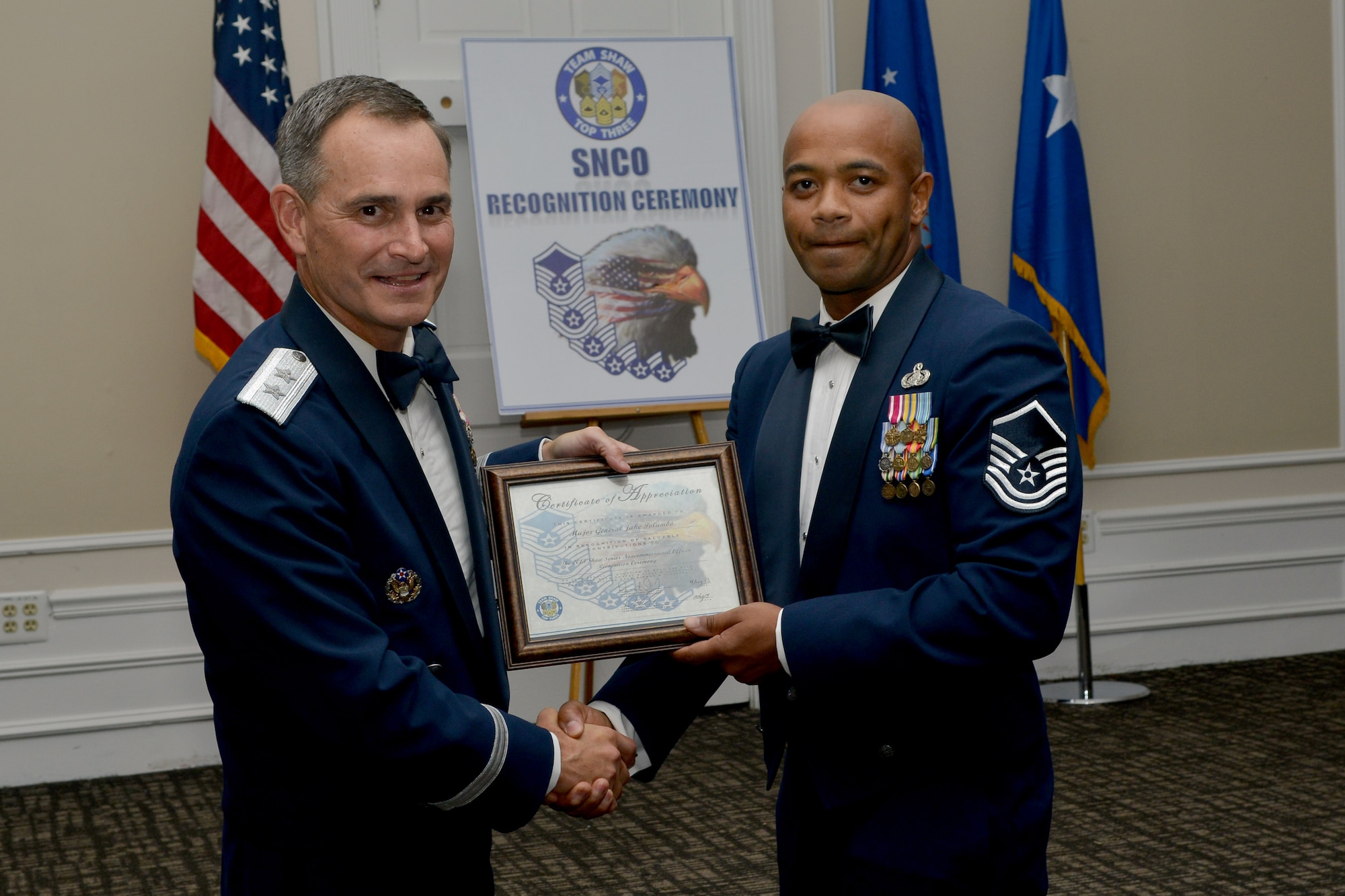 U.S. Air Force Maj. Gen. Jake Polumbo, 9th Air Force commander, receives a certificate of appreciation from Master Sgt. Demetrius Jones, Shaw Top 3 president, during a senior NCO induction ceremony, Shaw Air Force Base, S.C., Aug. 9, 2013. The ceremony was held to welcome new master sergeants to the senior enlisted tier. (U.S. Air Force photo by Airman 1st Class Ashley L. Gardner/Released)