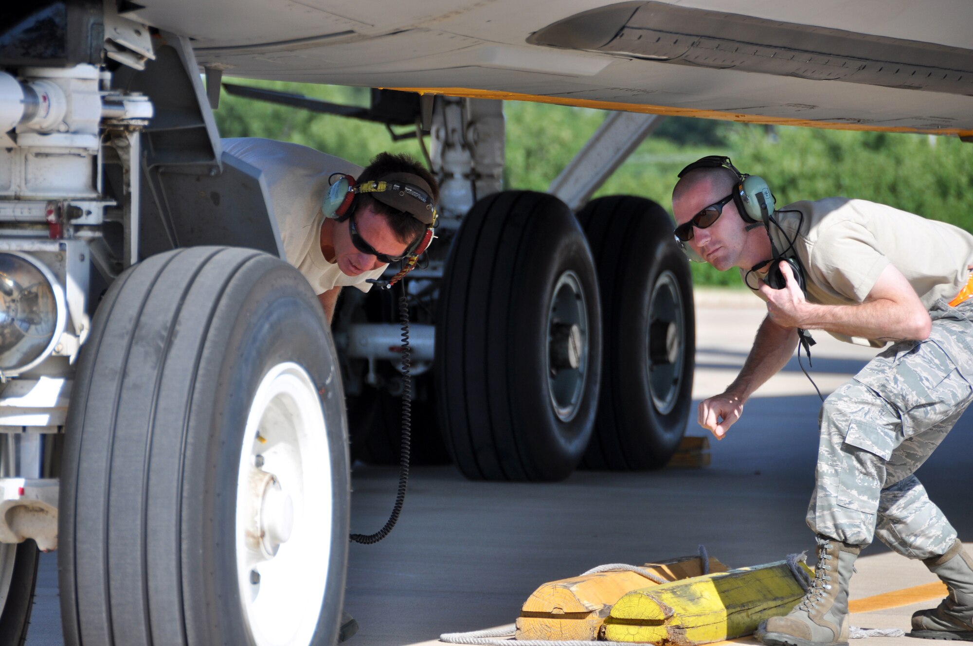 507th Aircraft Maintenance Squadron crew chief Tech. Sgt. Richard Baker, left, helps Senior Airman Matthew Dobbins of the Oklahoma Air National Guard 137th Air Refueling Wing pull chalks on a departing KC-135 Stratotanker.  Baker trains Dobbins on pre-flight and take-off procedures.  Integrating guard/reserve Airman on the flight line for aircraft launch and recovery is a unique opportunity to demonstrate the seamless guard/reserve association here.  (U.S. Air Force photo/Senior Airman Mark Hybers)