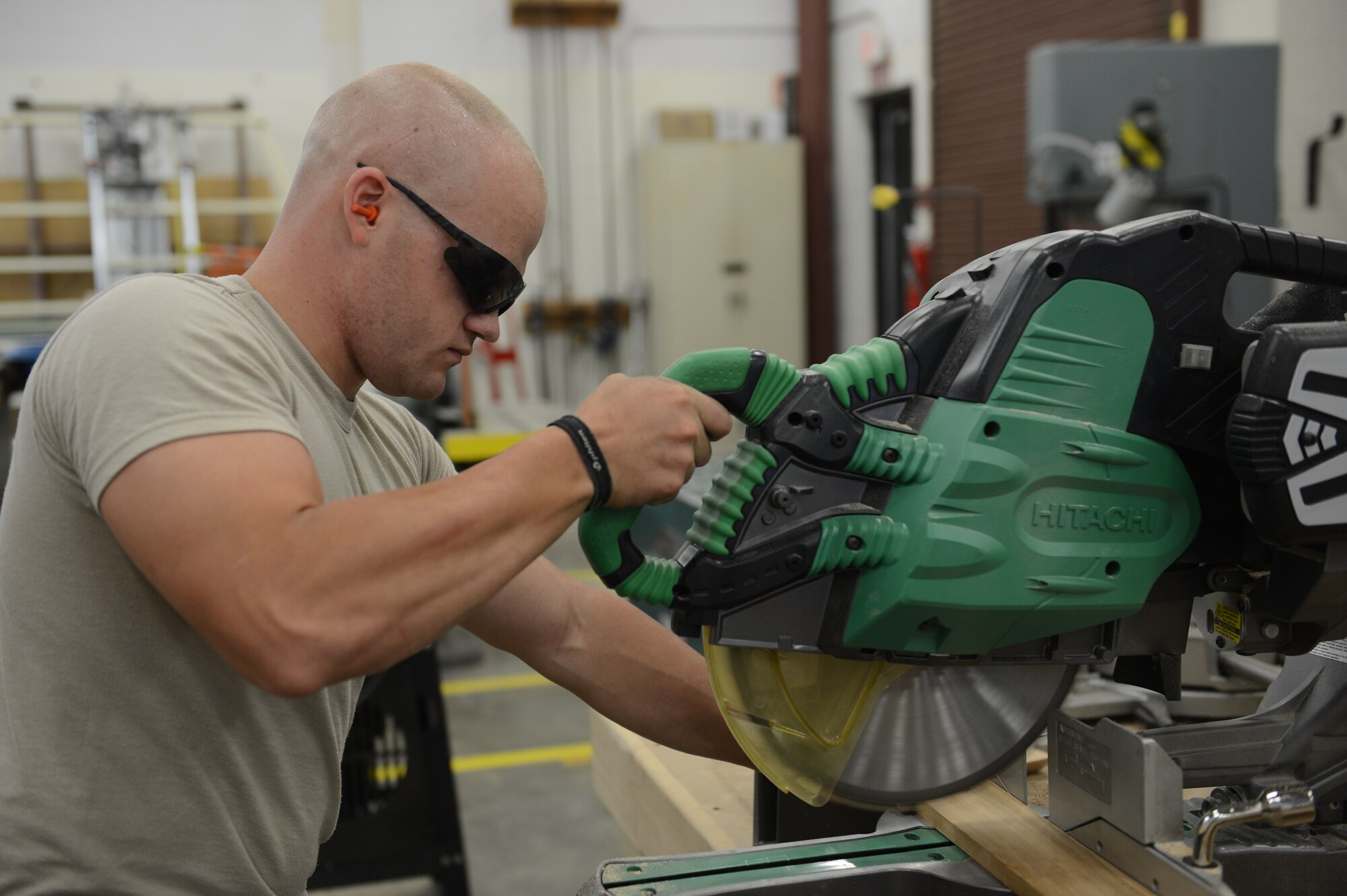 Airman 1st Class Corey Freeman, 20th Civil Engineer Squadron structural apprentice, cuts wood with a band saw at Shaw Air Force Base, S.C., July 18, 2013. The 20th CES structural flight maintains and repairs base facility structures. (U.S. Air Force photo by Airman 1st Class Krystal M. Jeffers/Released)