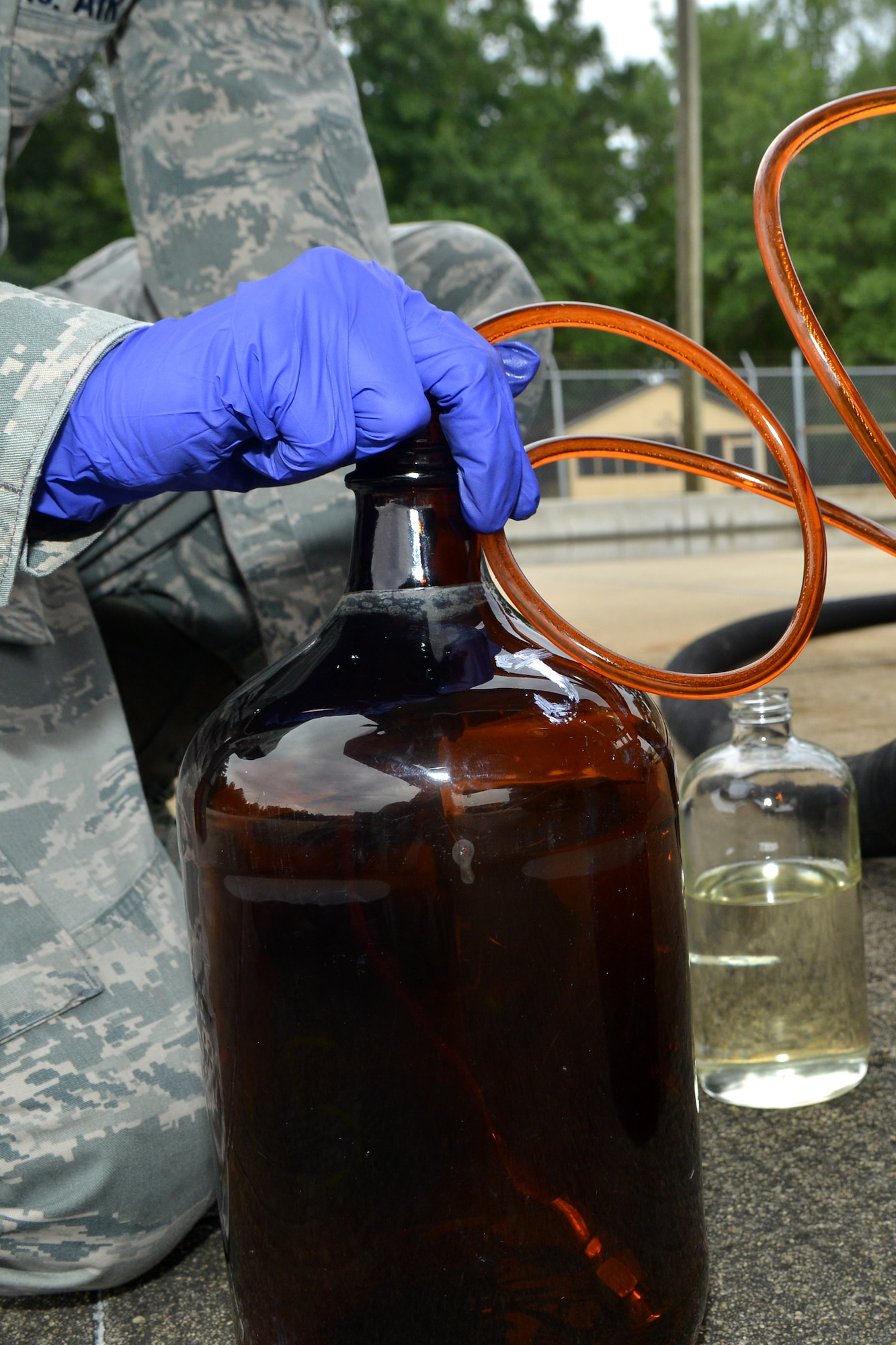 U.S. Air Force Senior Airman Christopher Dybalski, 20th Logistics Readiness Squadron fuels laboratory technician, drains a small amount of fuel to be tested for contamination, Shaw Air Force Base, S.C., Aug. 7, 2013. The fuels laboratory monitors and maintains the quality of all aviation fuel, ground fuel and cryogenic products by taking and analyzing samples. (U.S. Air Force photo by Airman 1st Class Ashley L. Gardner/Released)