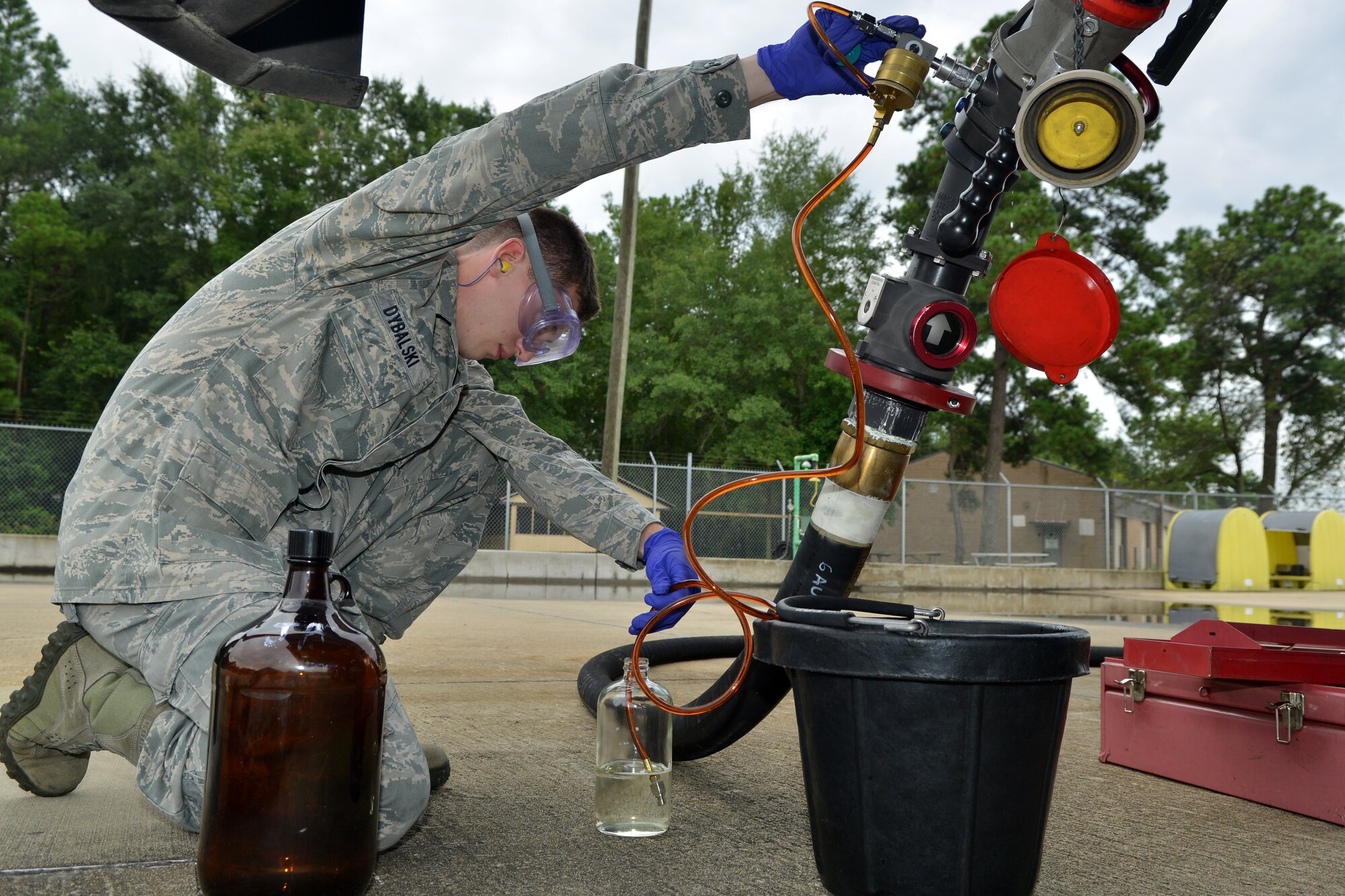 U.S. Air Force Senior Airman Christopher Dybalski, 20th Logistics Readiness Squadron fuels laboratory technician, drains a small amount of fuel to be tested from a fuel truck, Shaw Air Force Base, S.C., Aug. 7, 2013. Two Airmen test all these fueling stations to ensure that the fuel on base is held to the highest standards, ensuring the safest mission departure and return for the pilots.(U.S. Air Force photo by Airman 1st Class Ashley L. Gardner/Released)