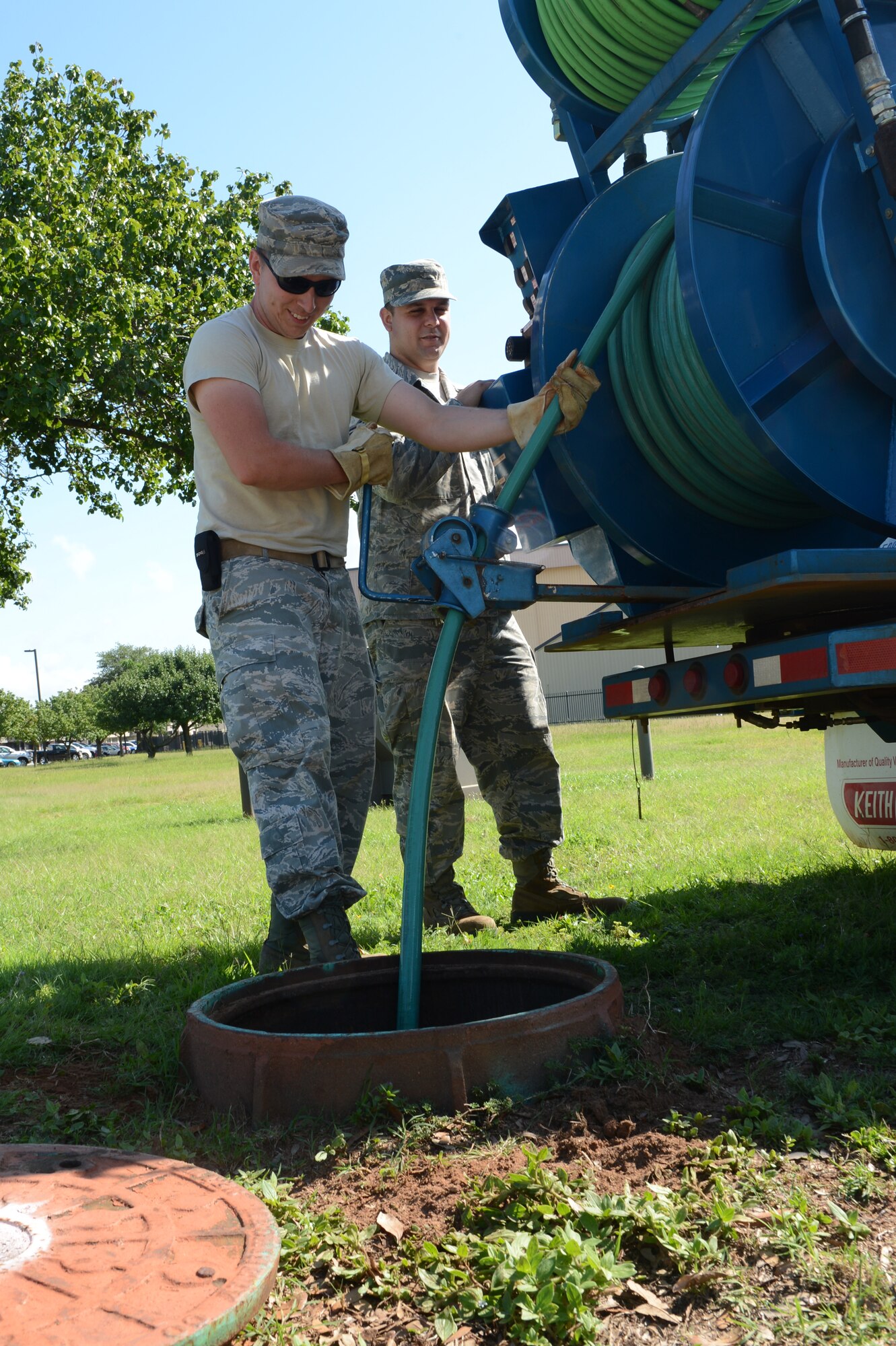 Staff Sgts. Jason Ball and Ryan Schmutzler, 20th Civil Engineer Squadron water and fuel systems technicians, clear a sewer pipe with pressurized water to prevent clogging, at Shaw Air Force Base, S.C., July 19, 2013. Some of the water and fuels system maintenance section’s responsibilities are monitoring the water, gas and sewage pipes on base for breaks, and ensuring the water is safe to drink. (U.S. Air Force photo by Airman 1st Class Krystal M. Jeffers/Released) 