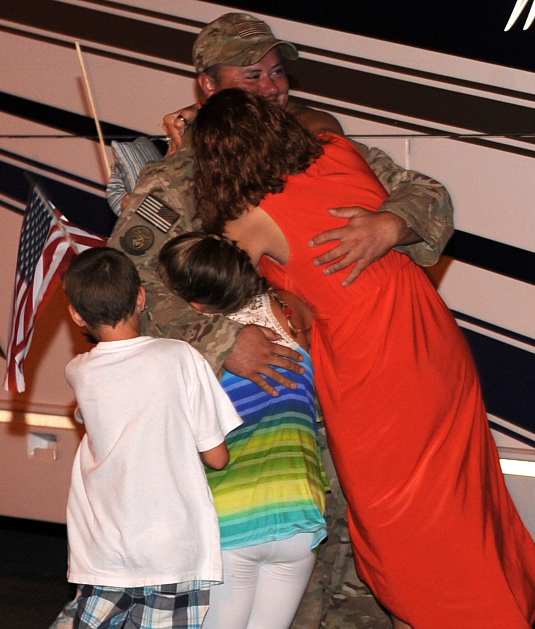 U.S. Air Force Tech. Sgt. John Phillips, 633rd Civil Engineer Squadron electrical systems noncommissioned officer in charge, greets his wife Rebecca, daughter Kalie and son Jeremy, after returning from deployment at Langley Air Force Base, Va., Aug. 7, 2013.  While deployed, Phillips ensured forward operating bases were in safe and working conditions. (U.S. Air Force photo by Senior Airman Brittany Paerschke-O’Brien/Released)