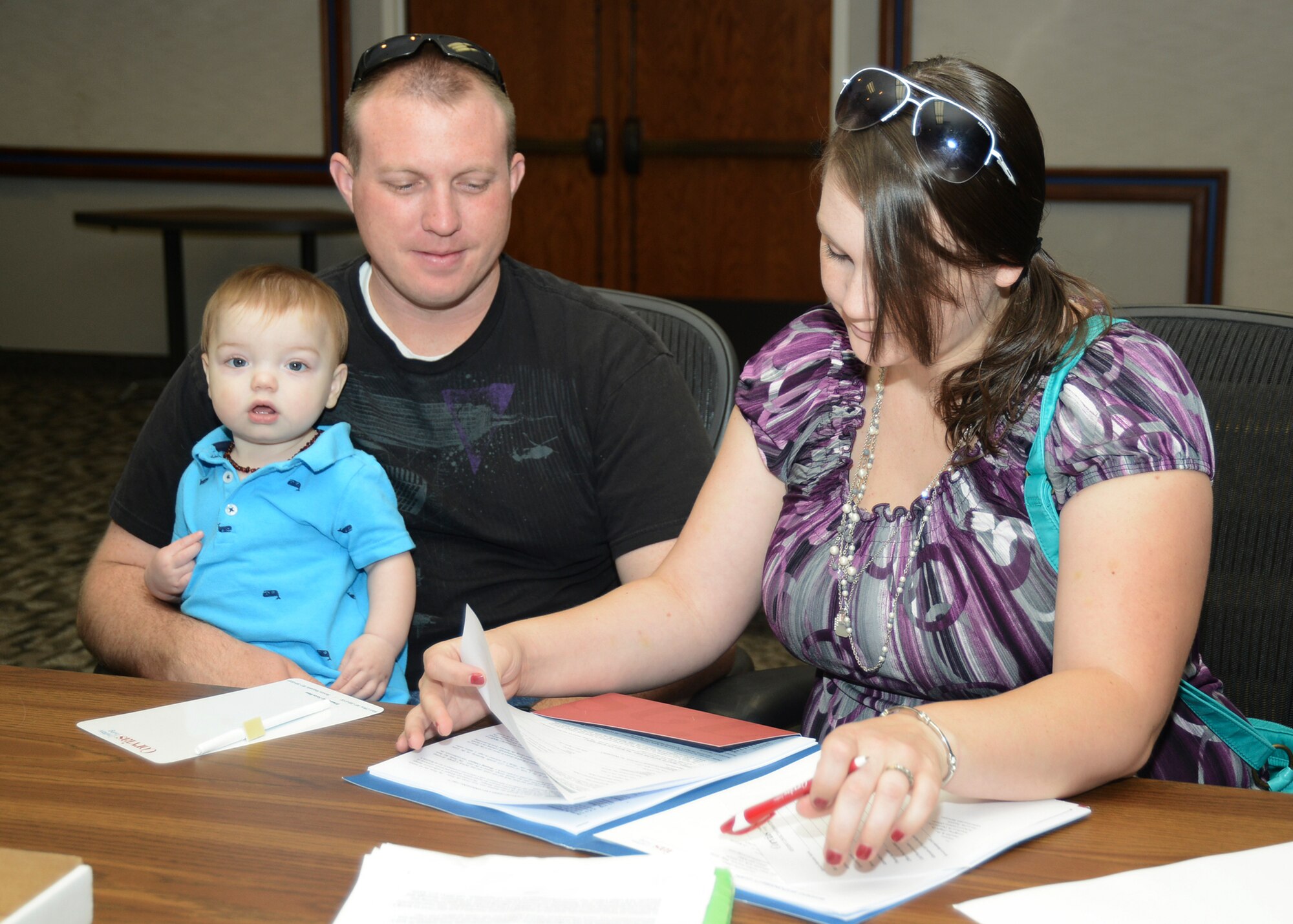 Staff Sgt. Sean Albright, 412th Security Forces Squadron, and his wife sign their  Resident Occupancy Agreement, a 12-month lease administered by Corvais Military Living, which is the private company that will oversee base housing beginning Sept. 1. (U.S. Air Force photo by Rebecca Amber)
