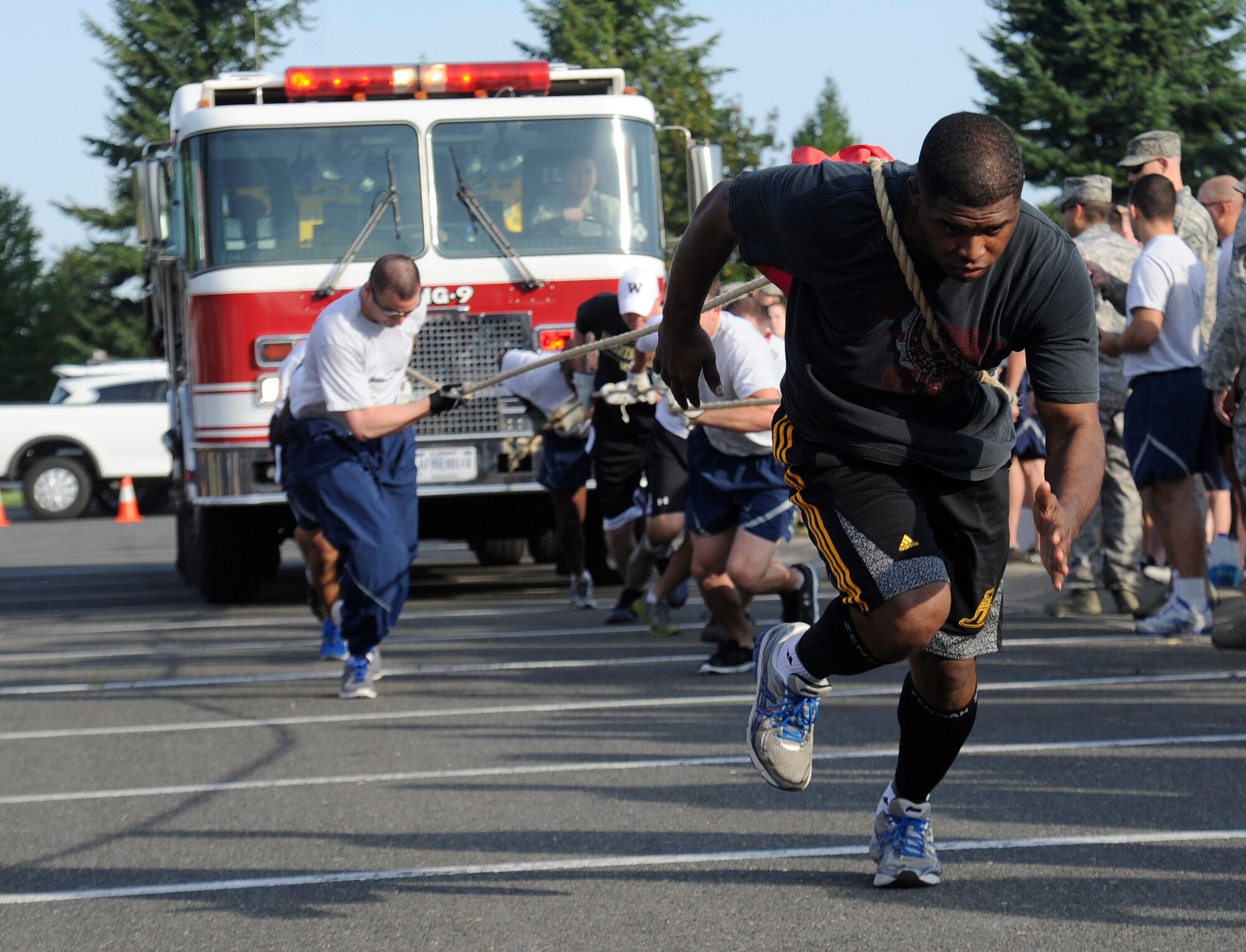 Members of Team Fairchild participate in the fire truck pull during the Commander’s Challenge event at Fairchild Air Force Base, Wash., Aug. 9, 2013. The Commander’s Challenge is comprised of four events to include a 1.6 mile run, the fire truck pull, tug of war and an obstacle course. (U.S. Air Force photo by Airman 1st Class Ryan Zeski/Released)