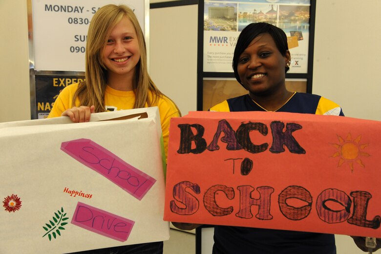 PETERSON AIR FORCE BASE, Colo. – Emily Wanderscheid (left), base Keystone Club vice president, and LaTanya McCray, R.P. Lee Youth Center teen advisor, kick-off this year’s back-to-school supply drive as they place the first donation boxes at the Base Exchange Aug. 8. This year the volunteers hope to double last year’s total donations in order to help 500 families prepare for the new school year. (U.S. Air Force Photo/Staff Sgt. J. Aaron Breeden)