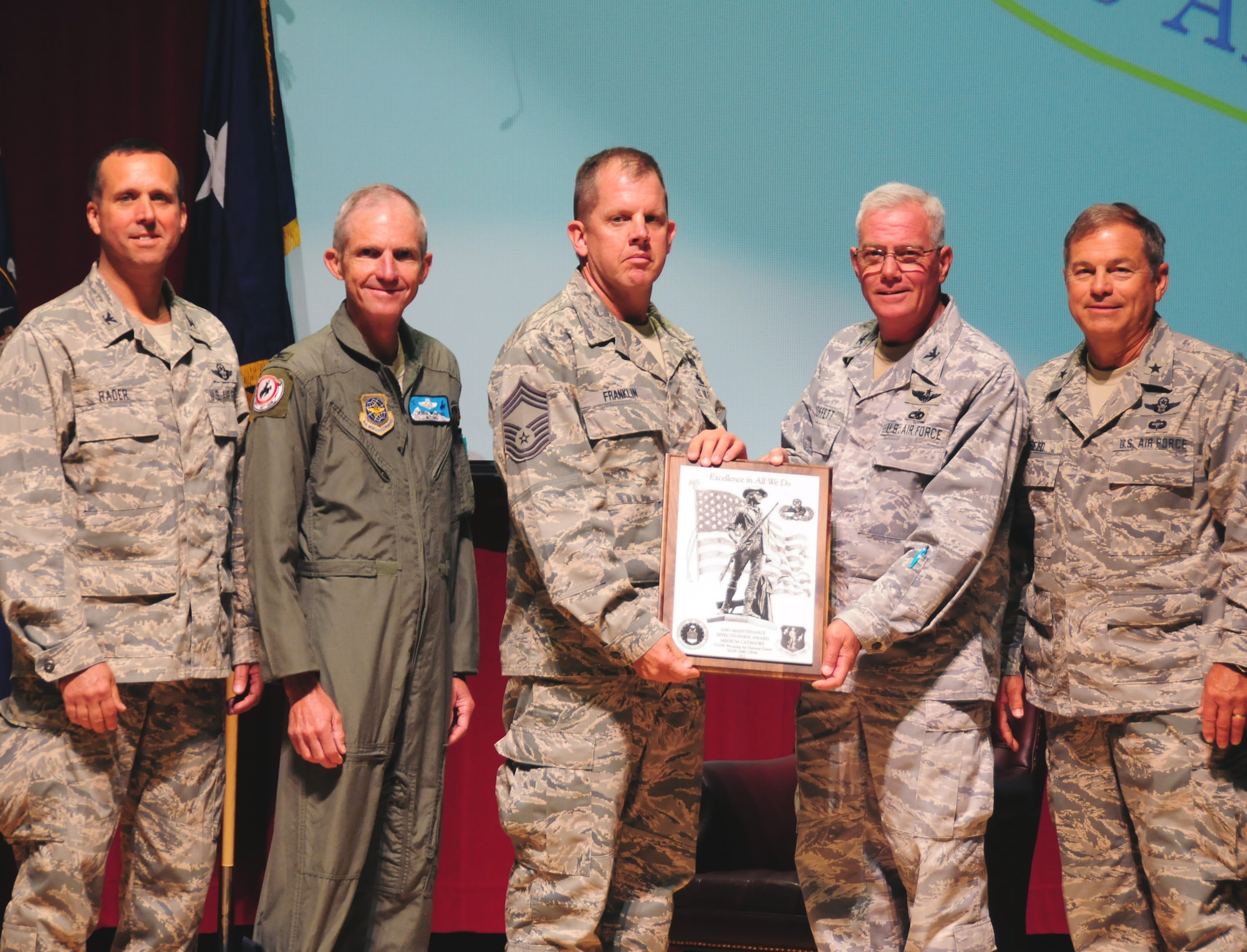 Col. James “Pat” Moffett, 153rd Maintenance Group commander, and Chief Master Sgt. Douglas Franklin, chief  of maintenance operations, accept the Air National Guard’s 2012 Maintenance Effectiveness Award in the medium category from Brig. Gen. Harold Reed (right), deputy adjutant general, Col. Dennis D. Grunstad II, assistant adjutant general-air, and Col. Stephen Rader (left), 153rd Airlift Wing commander, on August 2, 2013 at Central High School in Cheyenne, Wyo. (U.S. Air National Guard photo by Staff Sgt. John Galvin)