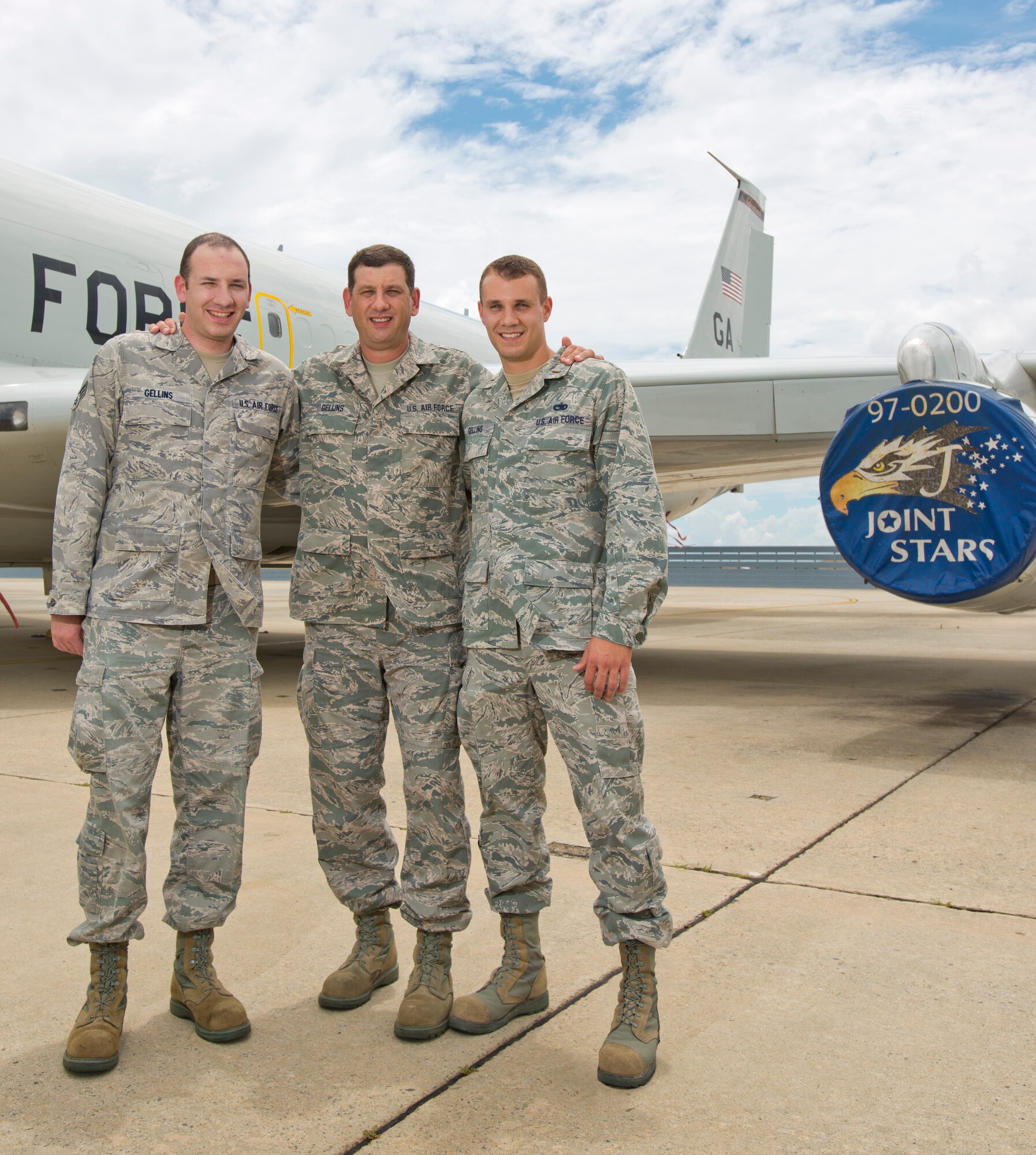 Master Sgt. Kenneth Gellins, center, poses with his sons 2nd Lt. Brett Gellins, right, and Senior Airman Casey Gellins, in front of an E-8C Joint STARS, Robins Air Force Base, Ga., July 14, 2013.  The father and sons, who currently serve together in the 116th Air Control Wing, Georgia Air National Guard, have a long history of family members who have served in the military dating back to the Revolutionary War. (Photo by Master Sgt. Roger Parsons/Released)