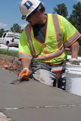 Gary Garcia smooths concrete on a median along Stadium Boulevard at the Air Force Academy Aug. 9, 2013. The 10th Civil Engineer Squadron is using the median as a test to determine the cost and savings of Xeriscaping instead of replacing strips of grass along the median every year. Garcia is an employee of Cosyleon and Cosyleon, a contractor based in Pueblo, Colo., that specializes in concrete placement. (U.S. Air Force photo/Don Branum)