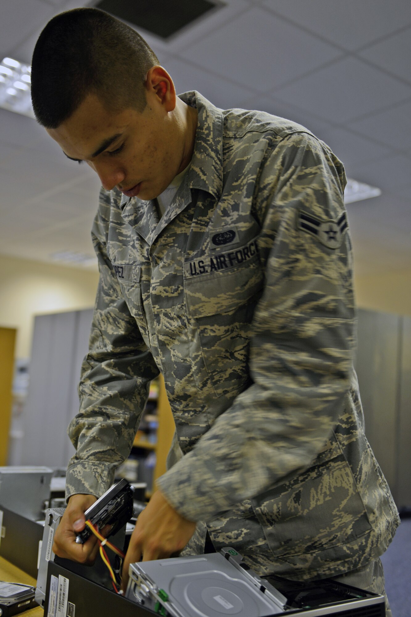 RAF CROUGHTON, United Kingdom –Airman 1st Class Juan Lopez, 422nd Communications Squadron client services center technician, removes a hard drive to degauss it. Hard drives on new computers are removed and degaussed before they are allowed on the network. (U.S. Air Force photo by Tech. Sgt. Chrissy Best)