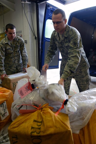 RAF CROUGHTON, United Kingdom – Staff Sgt. Brian Trahan and Senior Airman Donald Francisco, 422nd Communications Squadron post office, load bags of mail heading to RAF Alconbury. The RAF Croughton Post Office customer service counter is open from 9:30 a.m. to 5 p.m. Monday through Friday. (U.S. Air Force photo by Tech. Sgt. Chrissy Best)