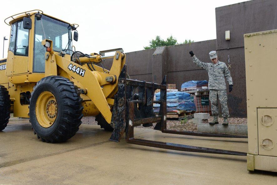 RAF CROUGHTON, United Kingdom – Senior Airman Johnathan Brewer(driving)  and Tech. Sgt. Whitney Hancock, both from the 422nd Civil Engineer Squadron power pro shop, prepare to move a generator from outside to inside the shop to begin work on it. The power pro shop was doing maintenance on the generator after being outside for an Armed Forces Entertainment event. (U.S. Air Force photo by Tech. Sgt. Chrissy Best)