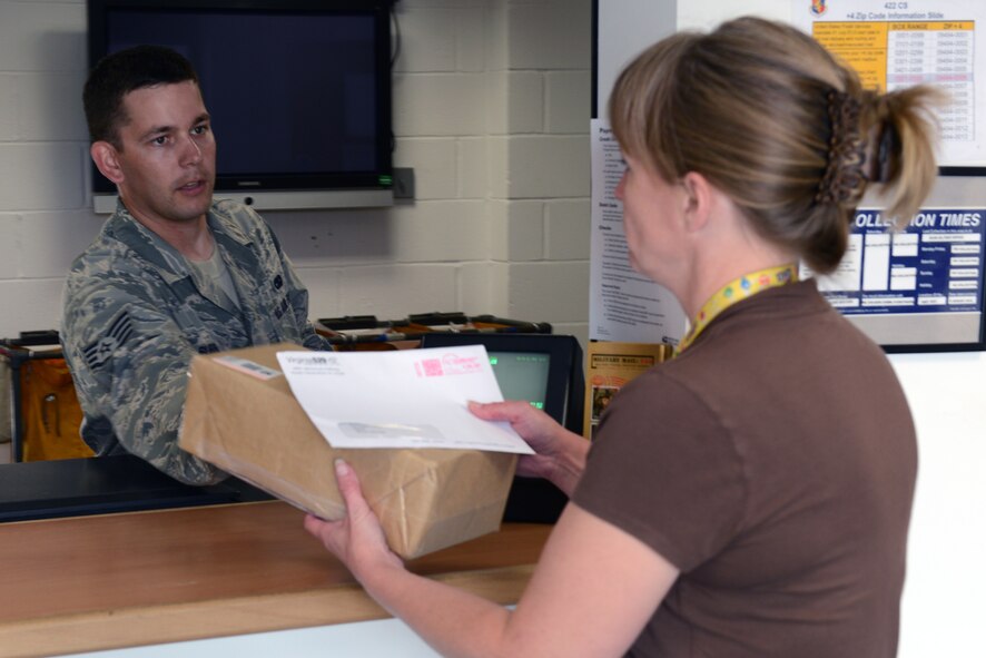 RAF CROUGHTON, United Kingdom – Staff Sgt. Patrick Burris, 422nd Communications Squadron postal clerk, distributes a package to a RAF Croughton Post Office customer July 23. The customer service counter at the post office is open from 9:30 a.m. to 5 p.m. Monday through Friday. (U.S. Air Force photo by Tech. Sgt. Chrissy Best)