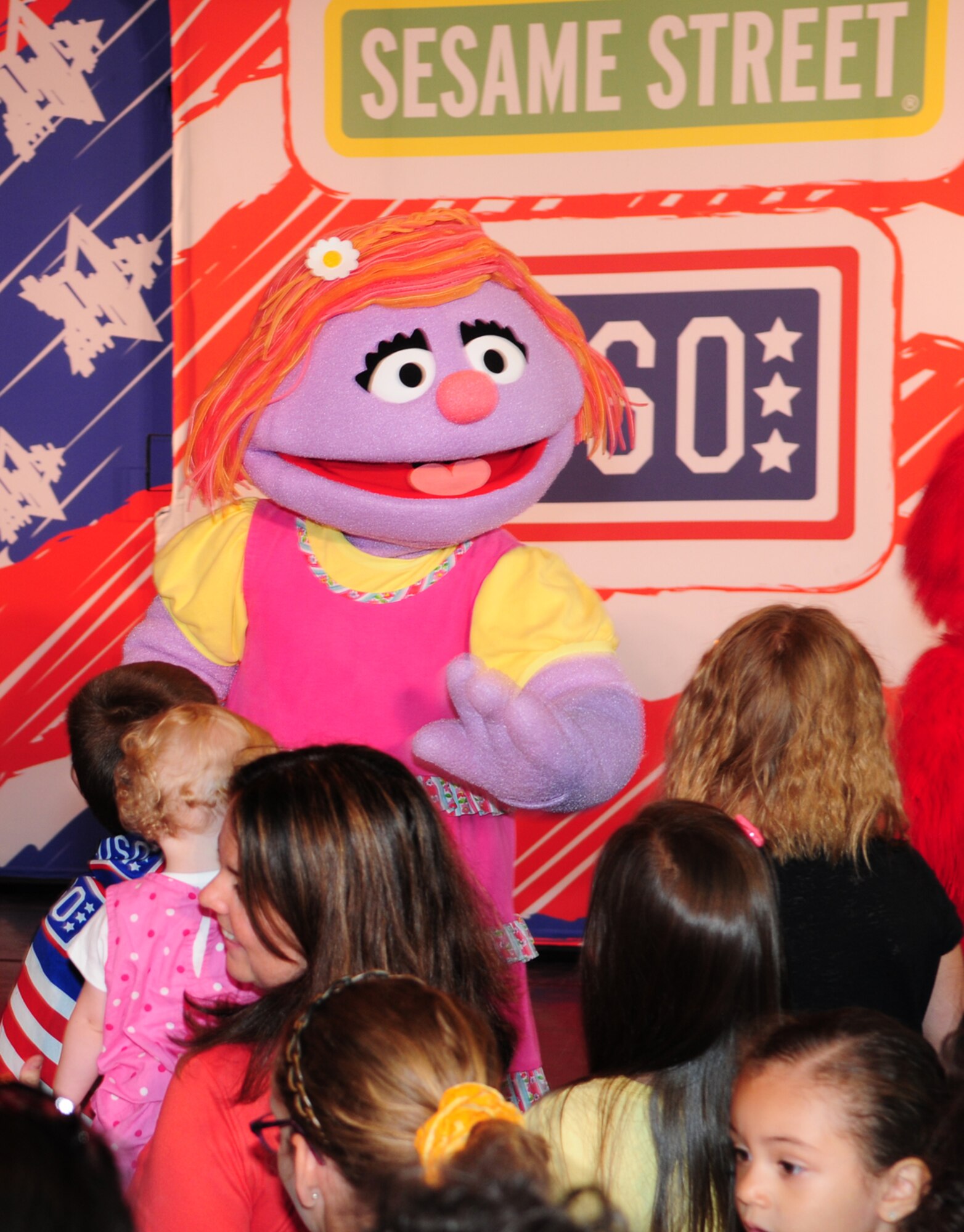 Katie, from the Sesame Street/United Services Organization Experience for Military Families greets children after a performance Aug. 12, 2013, in the North Side Fitness Center on RAF Mildenhall, England. Katie was sad because she would be leaving behind all her friends, but Grover, Elmo, Rosita and Cookie Monster taught her that change can be good, and that she would make new friends. The 2013 tour focused on the impact a military lifestyle has on children. (U.S. Air Force photo by Karen Abeyasekere/Released)