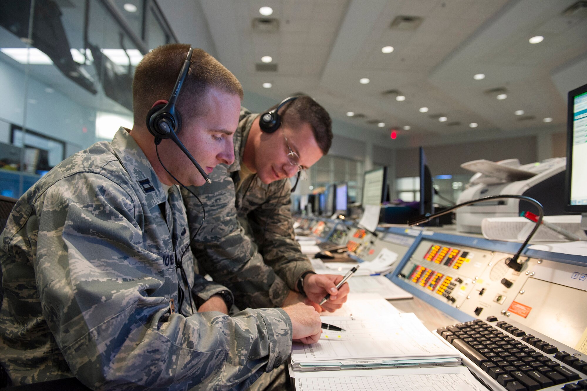 Capt. Justin Jones, left, and Capt. John Burton, both assigned with the 1st
Range Operations Squadron, go over mission-related data at the Morrell
Operations Center prior to the launch of WGS-6 from Complex 37 at Cape
Canaveral Air Force Station. (U.S. Air Force Photo/Matthew Jurgens)

