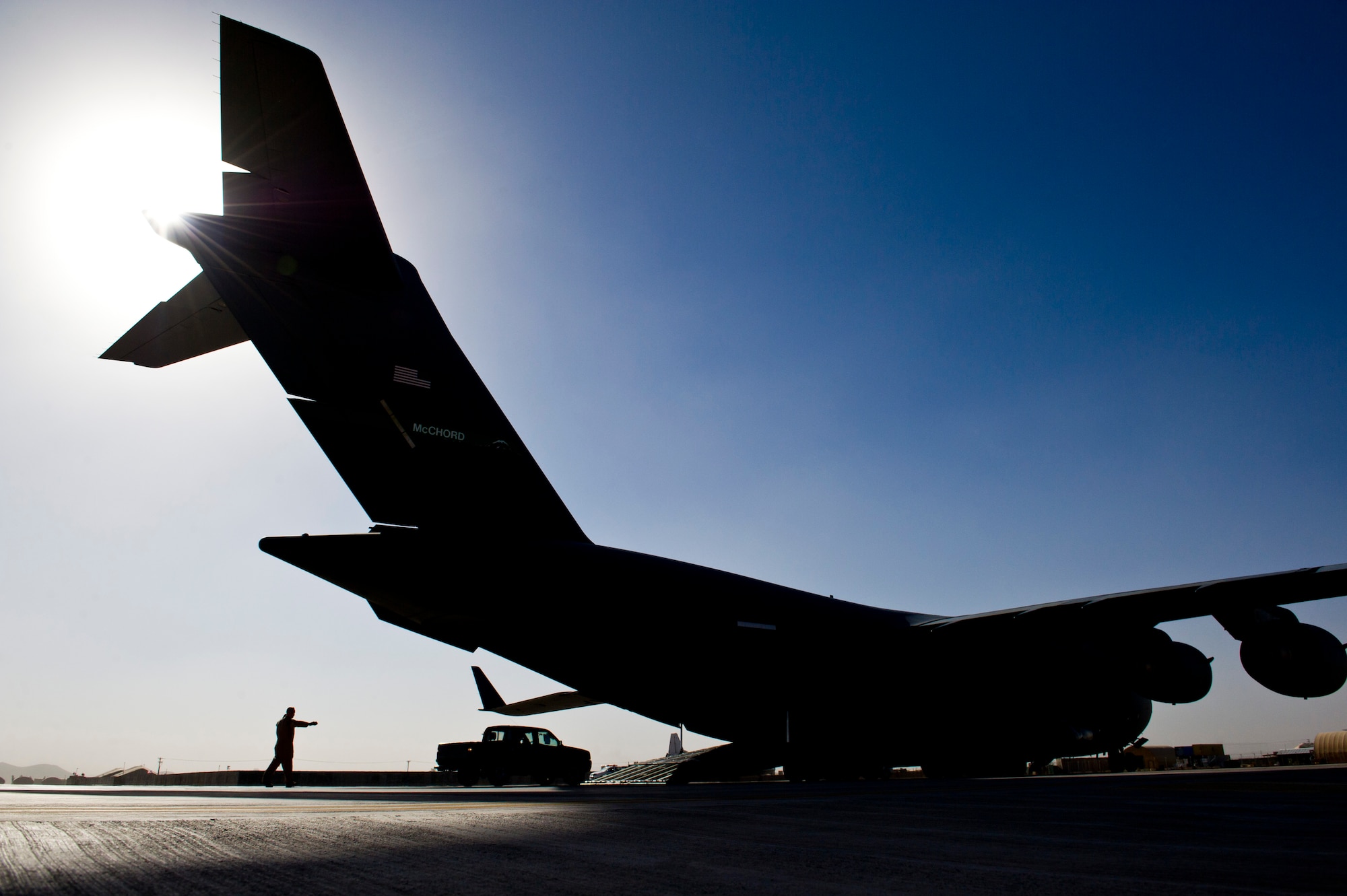 U.S. Air Force Tech. Sgt. Gary Washington, center, 316th Expeditionary Airlift Squadron C-17 Globemaster III loadmaster, off-loads vehicles during an airlift mission, July 25, 2013, Forward Operating Base Shindand Air Base, Herat, Afghanistan. The C-17 is capable of rapid strategic and tactical delivery of troops and any type of cargo around the Central Command area of reasonability. The aircraft can perform airlift, airdrop, and transport ambulatory patients during aeromedical evacuations when required. (U.S. Air Force photo/Staff Sgt. Marleah Miller)