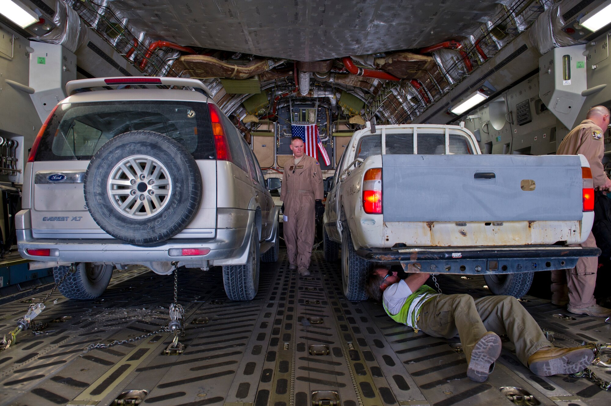 U.S. Air Force Tech. Sgt. Gary Washington, center, 316th Expeditionary Airlift Squadron C-17 Globemaster III loadmaster, loads vehicles that will be transferred to a different locations during an airlift mission, July 25, 2013, Bagram Air Base, Afghanistan. The C-17 is capable of rapid strategic and tactical delivery of troops and any type of cargo around the Central Command area of reasonability. The aircraft can perform airlift, airdrop, and transport ambulatory patients during aeromedical evacuations when required. (U.S. Air Force photo/Staff Sgt. Marleah Miller)