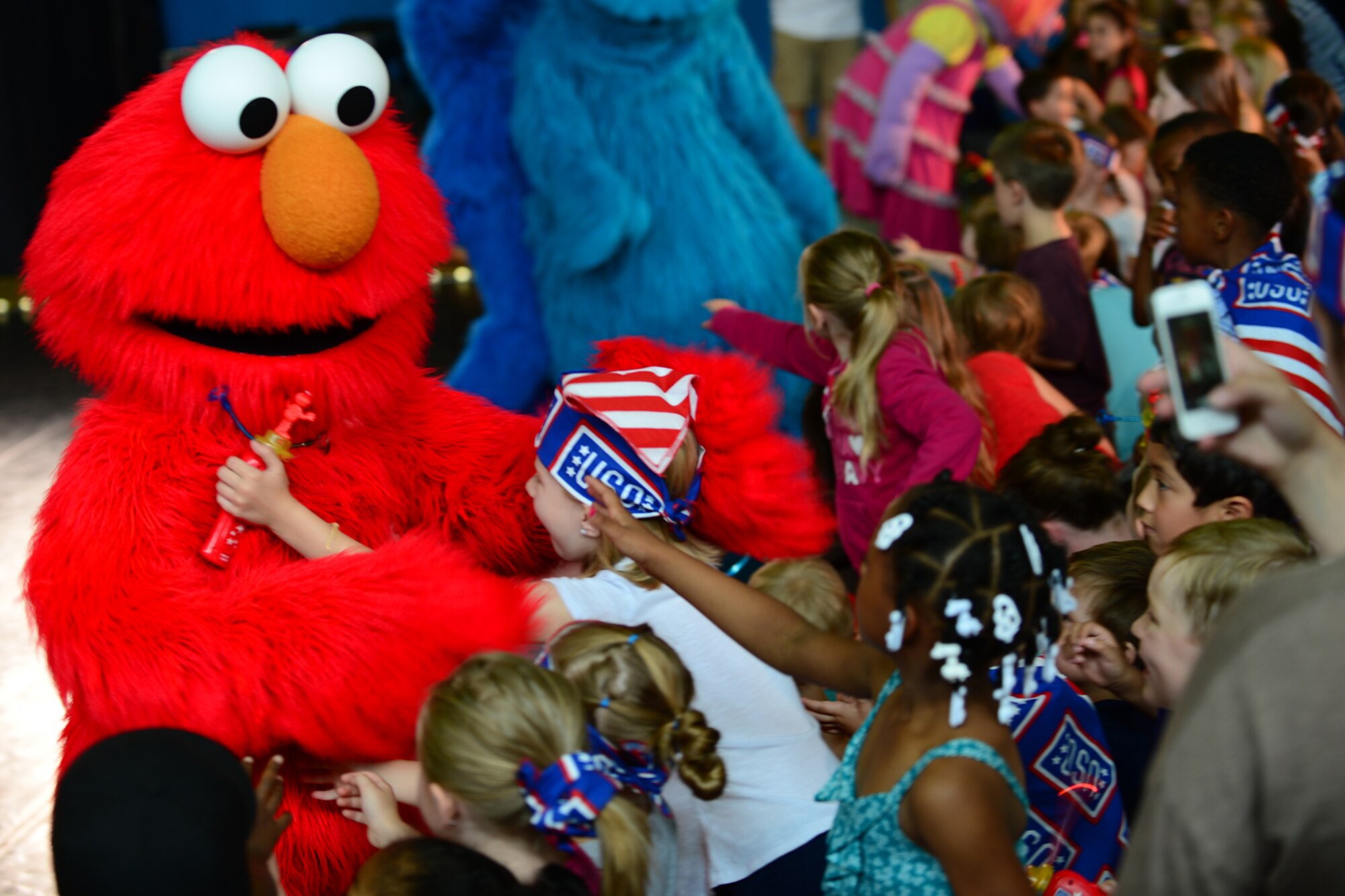 Sesame Street’s Elmo walks into the crowd during the Sesame Street/USO Experience at Royal Air Force Lakenheath, England, Aug. 10, 2013. The Sesame Street/USO Experience for Military Families is the USO’s longest-running, free-traveling tour based on Sesame Street's military family initiative. The tour is traveling to 42 installations in eight countries in the European and Pacific regions. (U.S. Air Force photo by Airman 1st Class Dana J. Butler/Released)