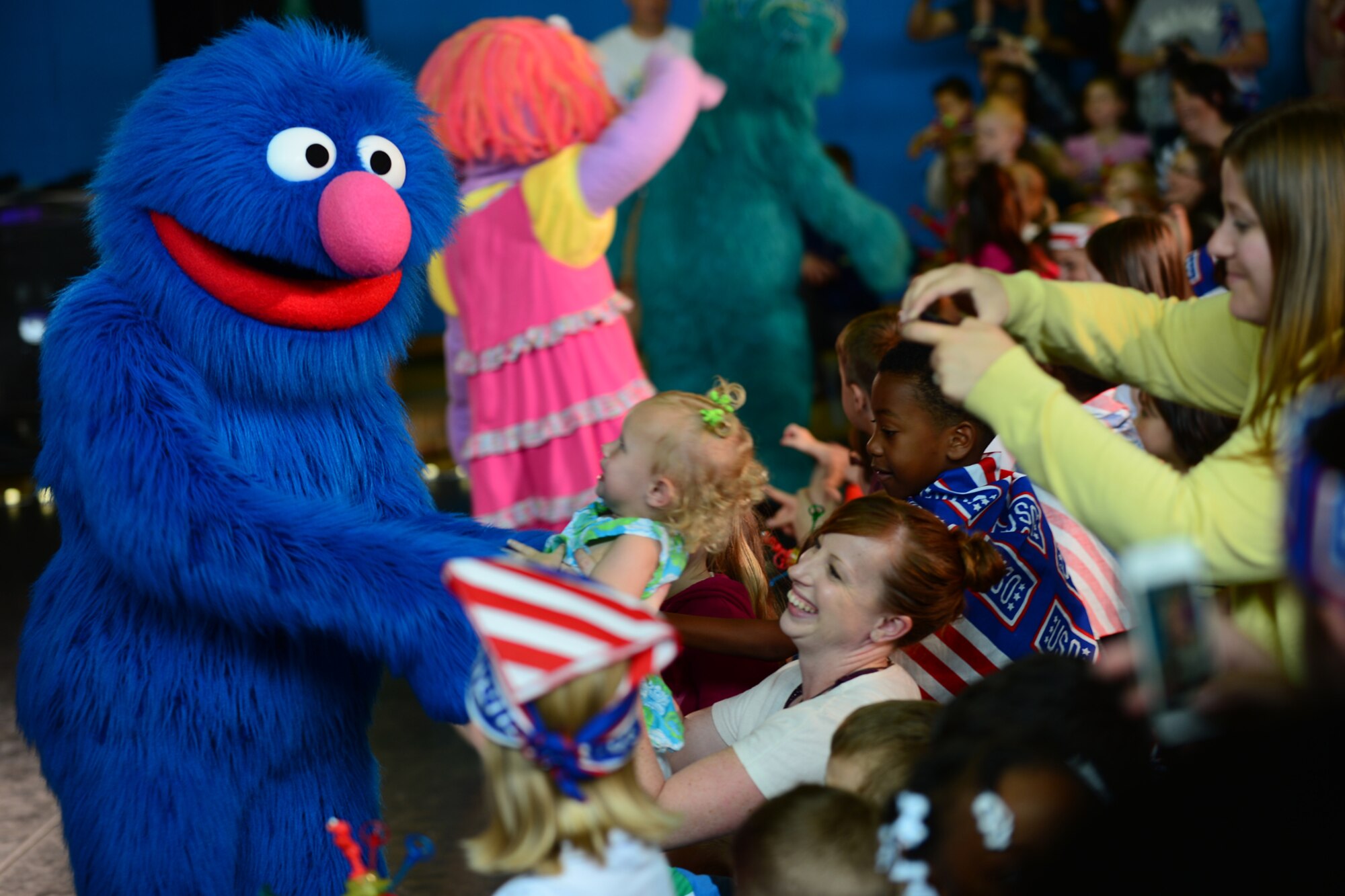 Sesame Street’s Grover walks into the crowd during the Sesame Street/USO Experience at Royal Air Force Lakenheath, England, Aug. 10, 2013. The Sesame Street/USO Experience for Military Families is the USO’s longest-running, free-traveling tour based on Sesame Street's military family initiative. The tour is traveling to 42 installations in eight countries in the European and Pacific regions. (U.S. Air Force photo by Airman 1st Class Dana J. Butler/Released)
