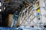 Staff Sgt. Brian Leach, an aerial port ramp supervisor from the Kentucky Air National Guard's123rd Contingency Response Group, pushes a pallet of cargo from a C-17 during Exercise Eagle Flag at Joint Base McGuire-Dix-Lakehurst, N.J., on March 28, 2012.