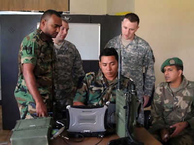 South Dakota Natonal Guard members collaborate with Suriname forces in radio operation.