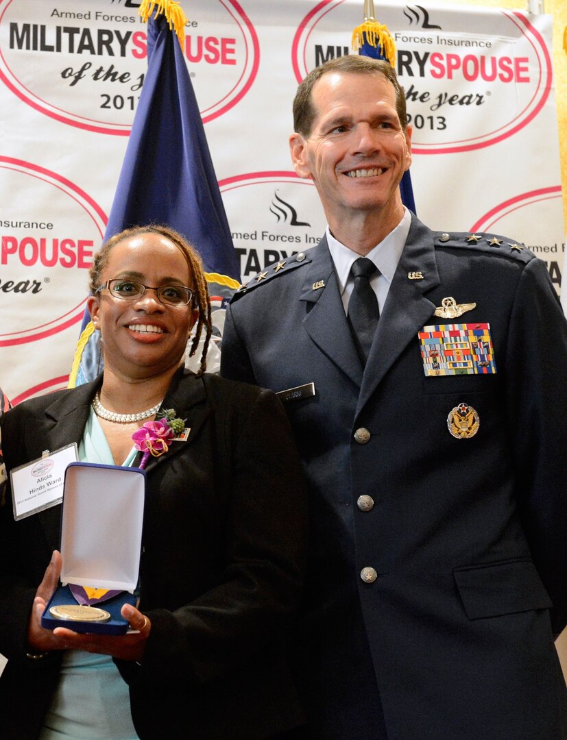 Alicia Hinds Ward accepts the 2013 Military Spouse of the Year award alongside Lt. Gen. Stanley E. Clarke III, the director of the Air National Guard.
