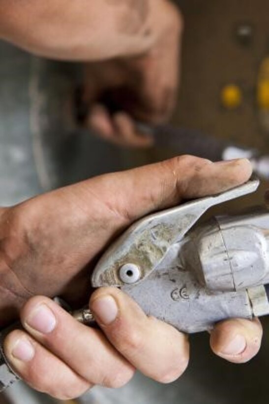 Cpl. Ethan Nash, an automotive organizational mechanic with Organic Maintenance Platoon, General Support Combat Logistics Company, Combat Logistics Regiment 2, removes a bolt from the rim of a tire at the Intermediate Maintenance Activity Lot tire shop, aboard Camp Leatherneck, Afghanistan.
