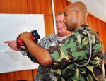 Lt. Col. Rob Larkin, commander of the 2-138th Field Artillery Regiment, shows a Special Mobile Force officer how to use a thermal imaging camera in Mauritius.