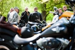 Participants in a motorcycle safety ride from the Marine Corps War Memorial just outside of Joint Base Myer-Henderson Hall to the National Museum of the Marine Corps gather around Lt. Devon H Foster, chaplain, to bless the bikes and start the ride with a prayer, May 3, 2013. Both Marines and Soldiers took part in the ride.