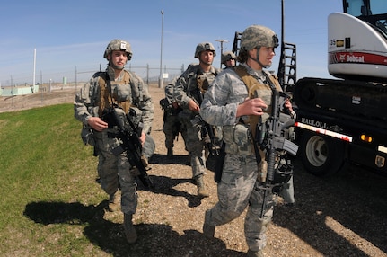 From left to right in foreground, U.S. Air Force Senior Airman Michael Carlson, Senior Airman Cody Jenson and Senior Airman Kathleen Stenger, all with the 219th Security Forces Squadron, North Dakota Air National Guard, walk away from a launch facility upon completion of an intense but routine exercise May 22, 2013, in the Minot Air Force Base missile field complex near Minot, N.D.