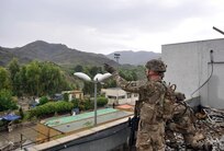 U.S. Army Sgt. 1st Class Thomas West points out the Pakistan border to Staff Sgt. Christopher Redd, kneeling, from an Afghan Border Police facility at Torkham Gate in eastern Afghanistan.