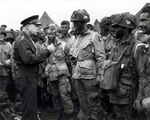 Gen. Dwight D. Eisenhower gives the order of the Day. "Full victory -- nothing else" to paratroopers in England just before they board their airplanes to participate in the first assault in the invasion of the continent of Europe. The Soldier wearing No. 23 is Wallace Strobel, who began his military career with the Michigan National Guard. The number corresponds to Strobel’s airplane number.