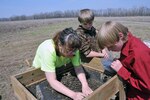Regina Meyer, cultural resource manager for the Missouri National Guard environmental office, sifts through soil samples with students to find Native American artifacts on April 5, 2013.