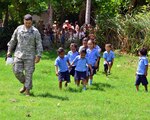 Lt. Col. Raymond Valas, Joint Task Force Jaguar commander, teaches the children of Central School, El Tamarindo, how to march, on their way out to look at Black Hawk helicopter May 14, 2013.