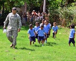 Lt. Col. Raymond Valas, Joint Task Force Jaguar commander, teaches the children of Central School, El Tamarindo, how to march, on their way out to look at Black Hawk helicopter May 14, 2013.