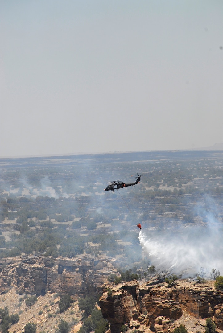 A UH-6-0 Blackhawk helicopter from the Colorado Army National Guard's 2nd Battalion, 135th General Support Aviation, drops 500 gallons of river water onto a wildfire burning the training range at Fort Carson, Colo., June 13, 2008.