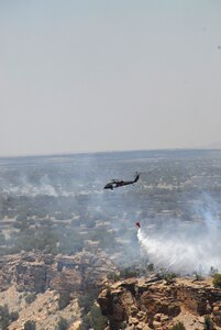 A UH-6-0 Blackhawk helicopter from the Colorado Army National Guard's 2nd Battalion, 135th General Support Aviation, drops 500 gallons of river water onto a wildfire burning the training range at Fort Carson, Colo., June 13, 2008.