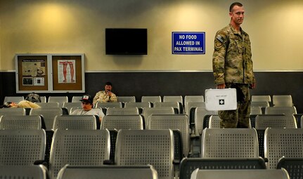 Senior Airman David Kitchen holds a first aid kit he has used many times when aiding passengers at Bagram Air Field, Afghanistan.