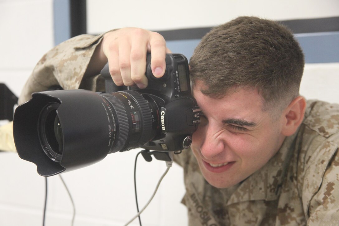 Pfc. Anthony J. Brosilow, a combat photographer with Station Combat Camera, photographs a customer in the photo studio Tuesday. 