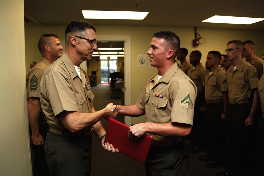Brig. Gen. Robert F. Castellvi, Marine Corps Installations East commanding general, awards Lance Cpl. Derek Johnson, an administrative specialist with Cherry Point Installation Personnel Administration Center, the Cherry Point Hard Charger of the Week award Aug. 2. The award is designed to honor the most motivated, hardest working junior Marine in their work section.