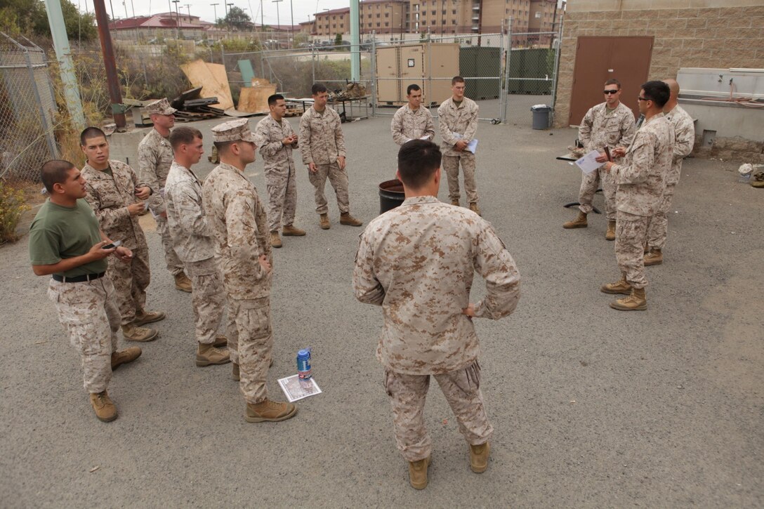 Capt. Michael Christman, an air officer at 1st Air Naval Gunfire Liaison Company, talks to three firepower control teams about their mission during and exercise at Camp Pendleton, Calif., Aug. 8. Understanding the language of the ANGLICO involves mastering multiple acronyms and radio operating procedures to help firepower control teams communicate targets to pilots during missions.