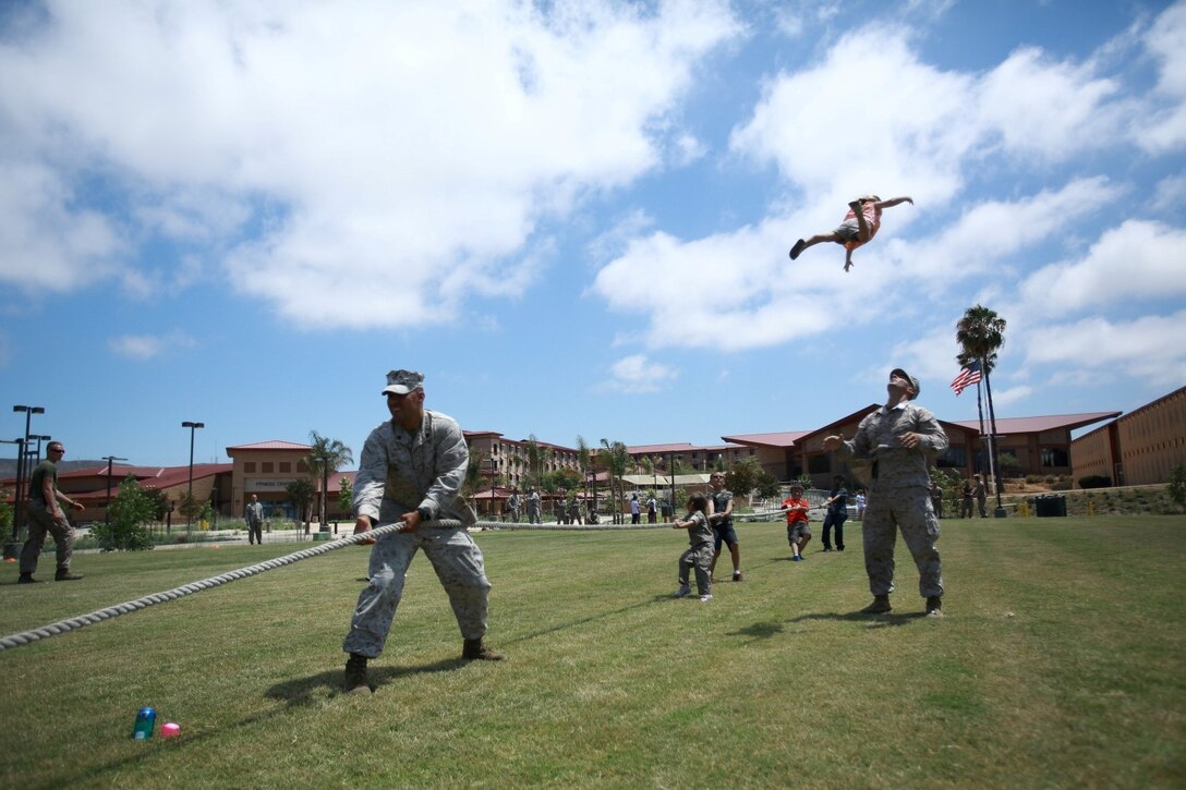 First Lt. Craig Dangel, supply officer, Headquarters and Service Company, 1st Light Armored Reconnaissance Battalion, plays with his daughter Layla during the battalion's Bring Your Kids to Work Day at Camp Las Flores here, Aug. 9, 2013. Highlanders, the battalion's nickname, and their children participated in field games such as the egg toss, three-legged race, tug of war and a modified version of the Combat Fitness Test during the family day event. Dangel is a native of Cincinnati.