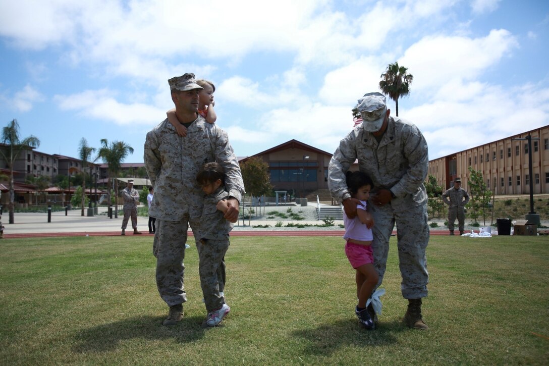First Lt. Craig Dangel, supply officer, Headquarters and Service Company, 1st Light Armored Reconnaissance Battalion, and his daughters Savannah and Layla, wait for the start of a three-legged race with Sgt. Raul Mantecon, motor transport operator, H&S Co., 1st LAR, and his daughter Leilani during the battalion's Bring Your Kids to Work Day at Camp Las Flores here, Aug. 9, 2013. Highlanders, the battalion's nickname, and their children participated in field games such as the egg toss, three-legged race, tug of war and a modified version of the Combat Fitness Test during the family day event. Dangel is a native of Cincinnati and Mantecon is a native of Wilmington, Calif.