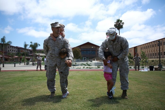 First Lt. Craig Dangel, supply officer, Headquarters and Service Company, 1st Light Armored Reconnaissance Battalion, and his daughters Savannah and Layla, wait for the start of a three-legged race with Sgt. Raul Mantecon, motor transport operator, H&S Co., 1st LAR, and his daughter Leilani during the battalion's Bring Your Kids to Work Day at Camp Las Flores here, Aug. 9, 2013. Highlanders, the battalion's nickname, and their children participated in field games such as the egg toss, three-legged race, tug of war and a modified version of the Combat Fitness Test during the family day event. Dangel is a native of Cincinnati and Mantecon is a native of Wilmington, Calif.