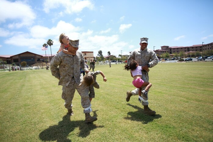 First Lt. Craig Dangel, supply officer, Headquarters and Service Company, 1st Light Armored Reconnaissance Battalion, his daughters Savannah and Layla, race against Sgt. Raul Mantecon, motor transport operator, H&S Co., 1st LAR, and his daughter Leilani during the battalion's Bring Your Kids to Work Day at Camp Las Flores here, Aug. 9, 2013. Highlanders, the battalion's nickname, and their children participated in field games such as the egg toss, three-legged race, tug of war and a modified version of the Combat Fitness Test during the family day event. Dangel is a native of Cincinnati and Mantecon is a native of Wilmington, Calif.