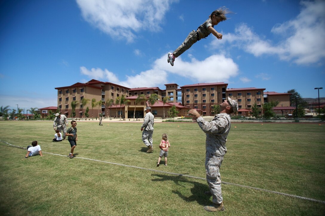 First Lt. Craig Dangel, supply officer, Headquarters and Service Company, 1st Light Armored Reconnaissance Battalion, plays with his daughter Layla during the battalion's Bring Your Kids to Work Day at Camp Las Flores here, Aug. 9, 2013. Highlanders, the battalion's nickname, and their children participated in field games such as the egg toss, three-legged race, tug of war and a modified version of the Combat Fitness Test during the family day event. Dangel is a native of Cincinnati.