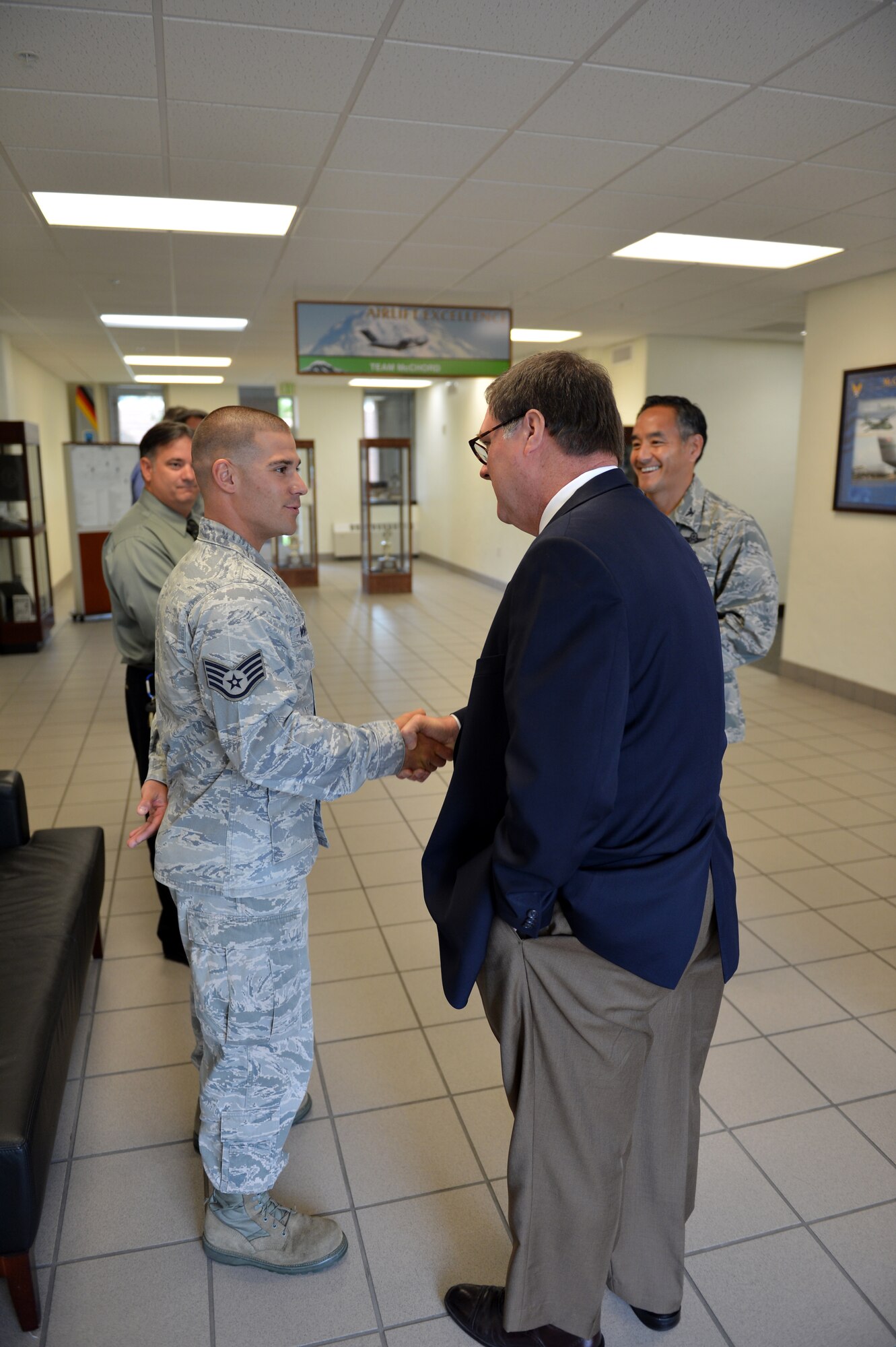 Staff Sgt. Jeffrey Winter, 62nd Medical Squadron aerospace medical technician, shakes hands with Congressman Denny Heck in the lobby of the 62nd Airlift Wing command building Aug. 14, 2013 at Joint Base Lewis-McChord, Wash. Winter currently supervises two Airmen and oversees daily operations for 16 clinical personnel at the McChord Field clinic. (U.S. Air Force photo/Staff Sgt. Jason Truskowski)  