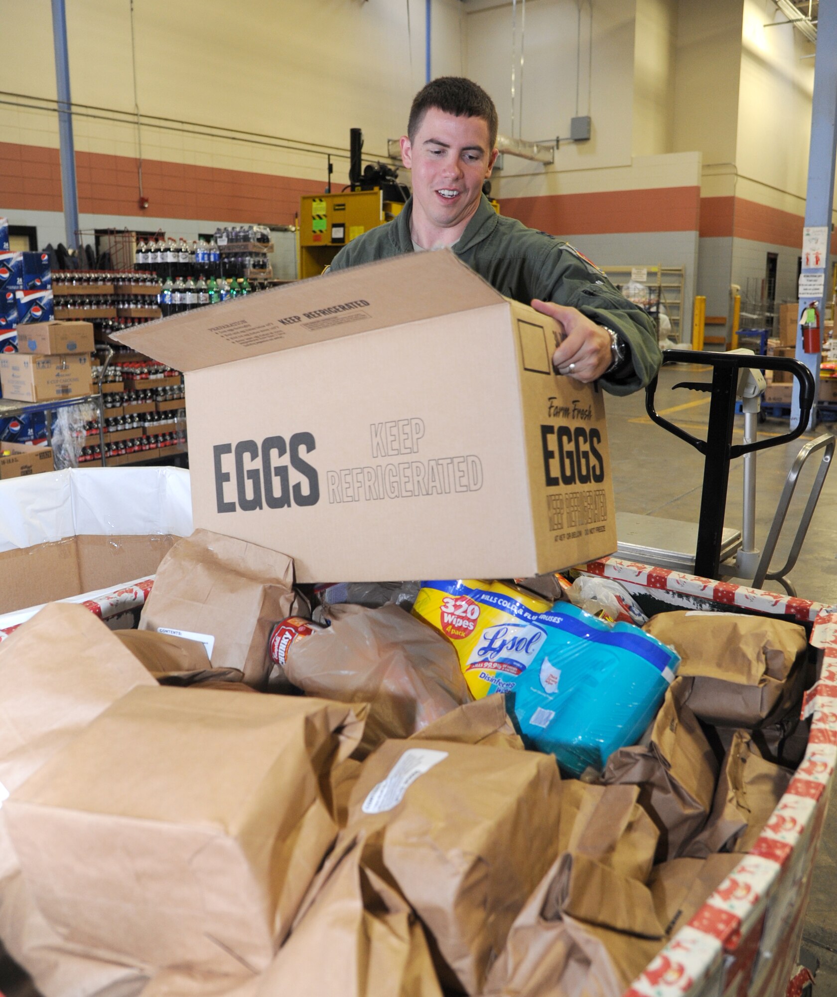 Capt. Christopher Hall, an instructor pilot with the 8th Flying Training Squadron, weighs food donations for the 2013 Feds Feed Families food drive underway at Vance Air Force Base, Okla. Team Vance has donated more than 700 pounds of food so far. (U.S. Air Force photo/ Senior Airman Frank Casciotta)